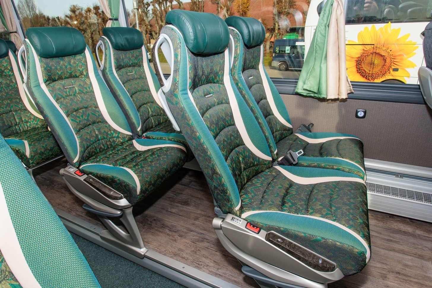 Komfortable gruene Sitzreihen in einem Reisebus von Bottenschein Reisen.