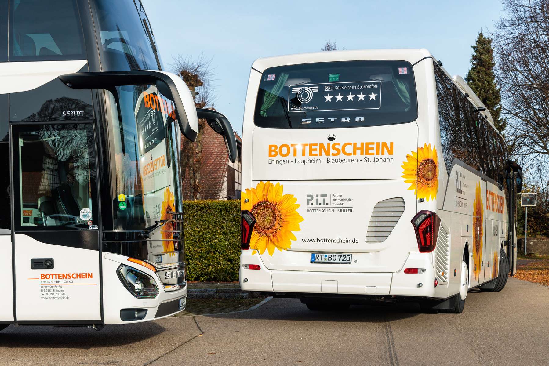 Zwei Busse von Bottenschein Reisen auf einem Parkplatz.