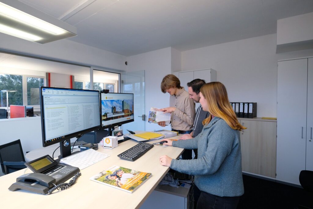 Drei Mitarbeiter arbeiten gemeinsam im Buero von Bottenstein Reisen.
