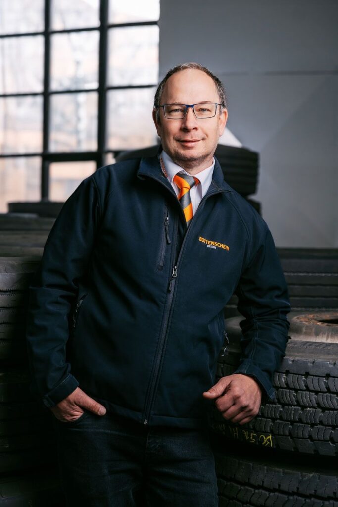 Ein Mann in einer modernen Bueroumgebung mit Jacke von Bottenstein Reisen.