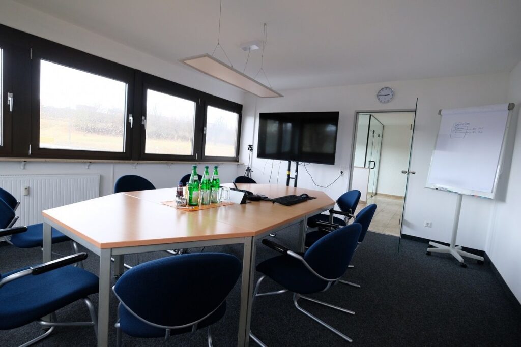 Moderner Konferenzraum bei Bottenschein Reisen mit großem Tisch und Stuehlen.