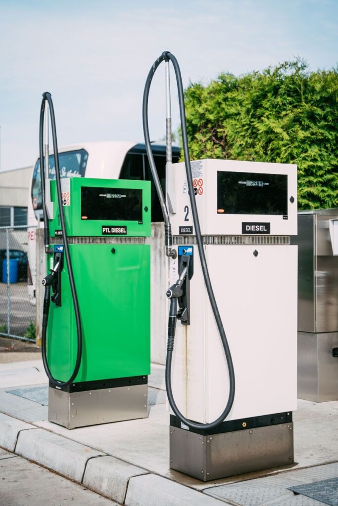Zwei moderne Zapfsaeulen auf einer Tankstelle bei sonnigem Wetter.